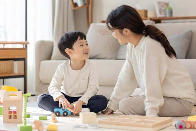 자폐 아동이 부모와 함께 장난감을 가지고 놀며 눈맞춤을 시도하는 모습