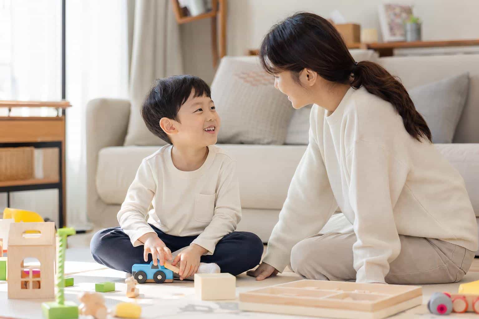 자폐 아동이 부모와 함께 장난감을 가지고 놀며 눈맞춤을 시도하는 모습